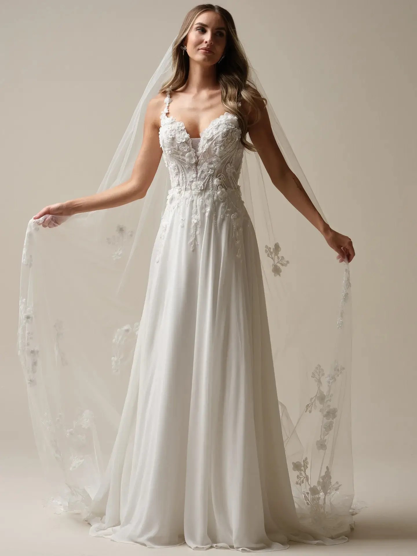 model is wearing an a-line wedding dress with 3D floral appliques