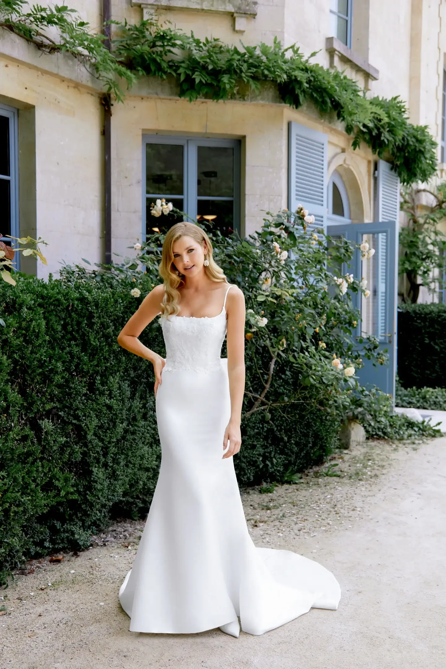 Model is wearing the Justin Alexander Sincerity 44510 gown, a Mikado fit and flare dress with beaded lace appliqués and delicate spaghetti straps.