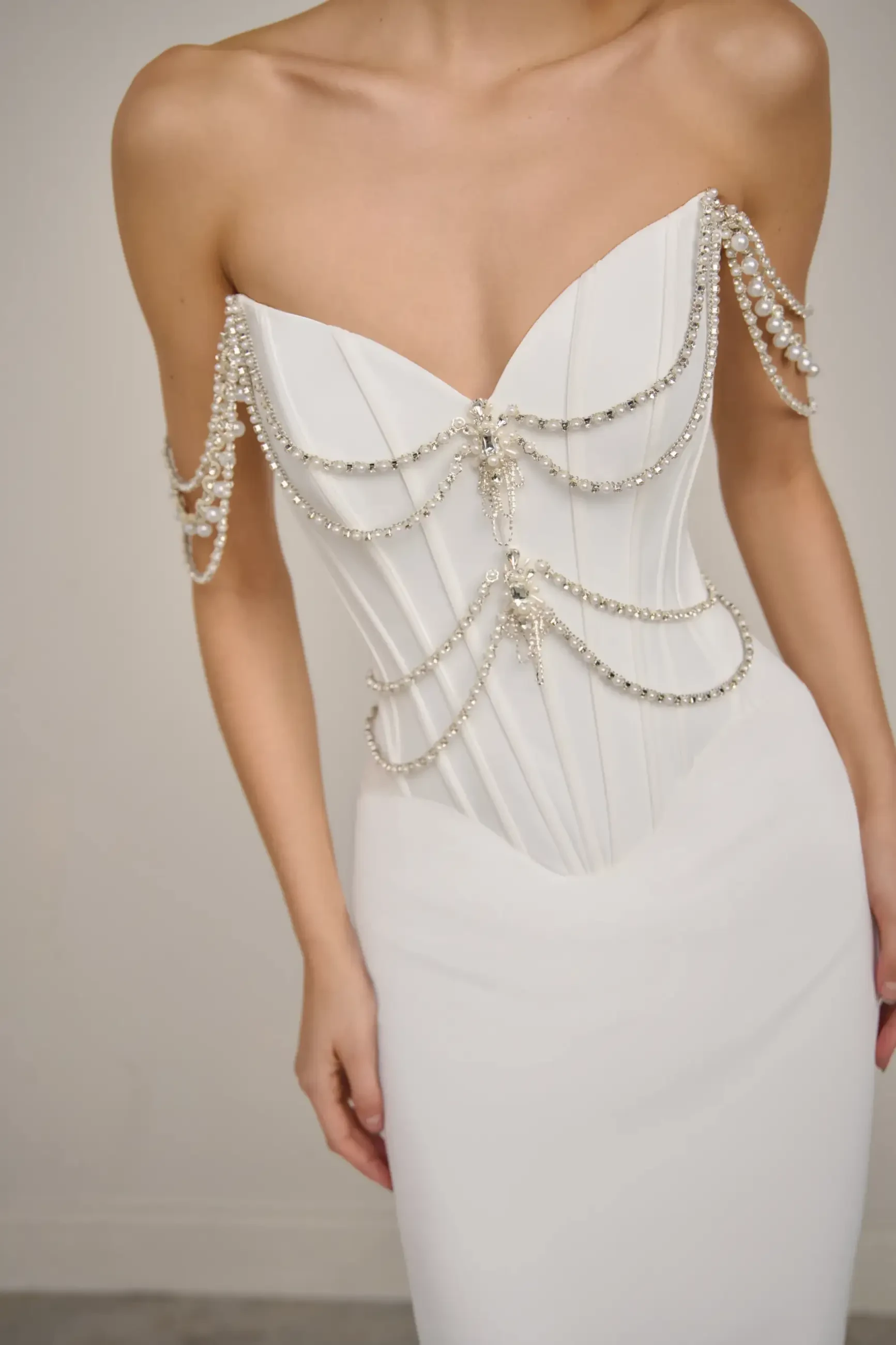 model is wearing a strapless off white wedding dress