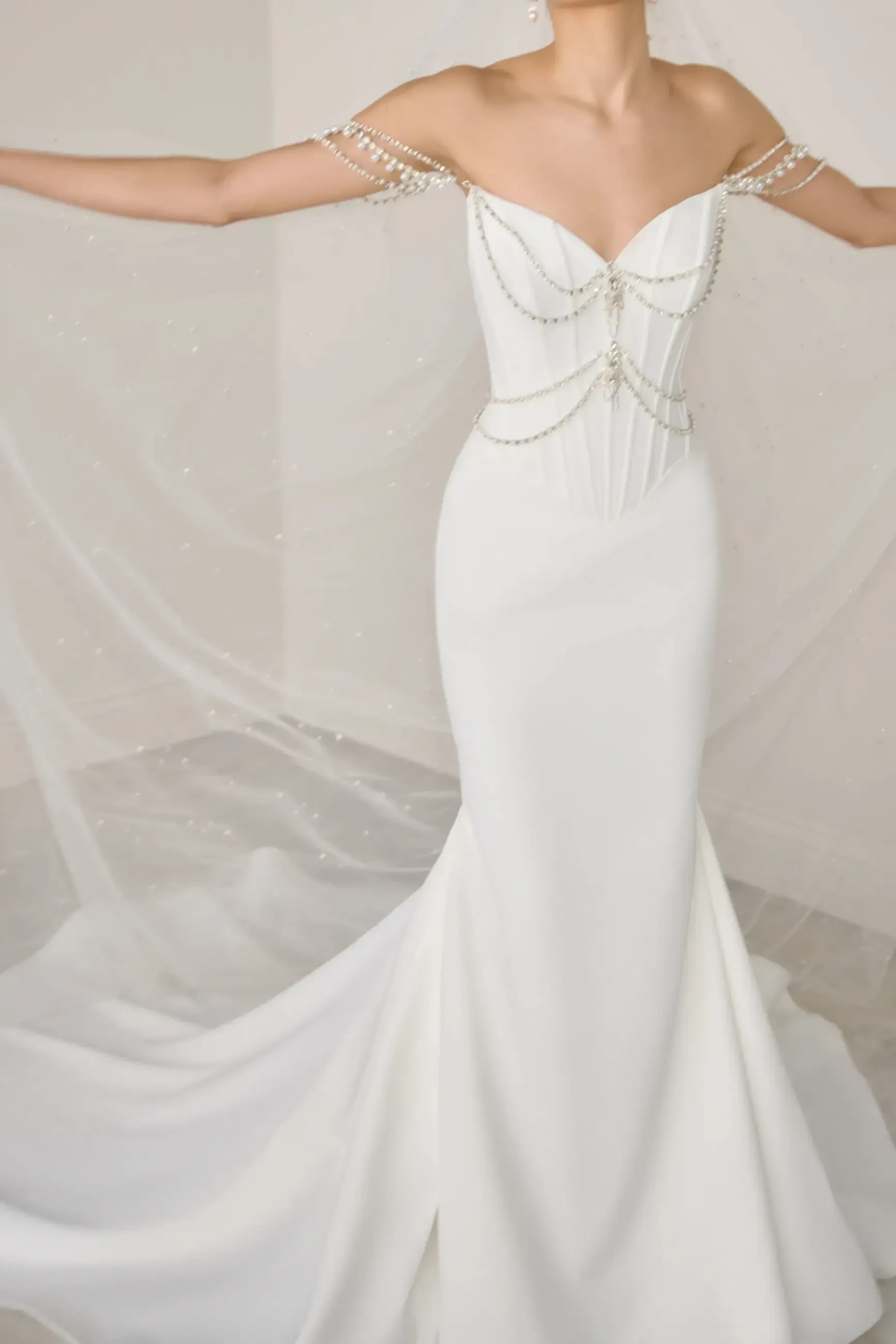 model is wearing an off the shoulder fit and flare bridal gown