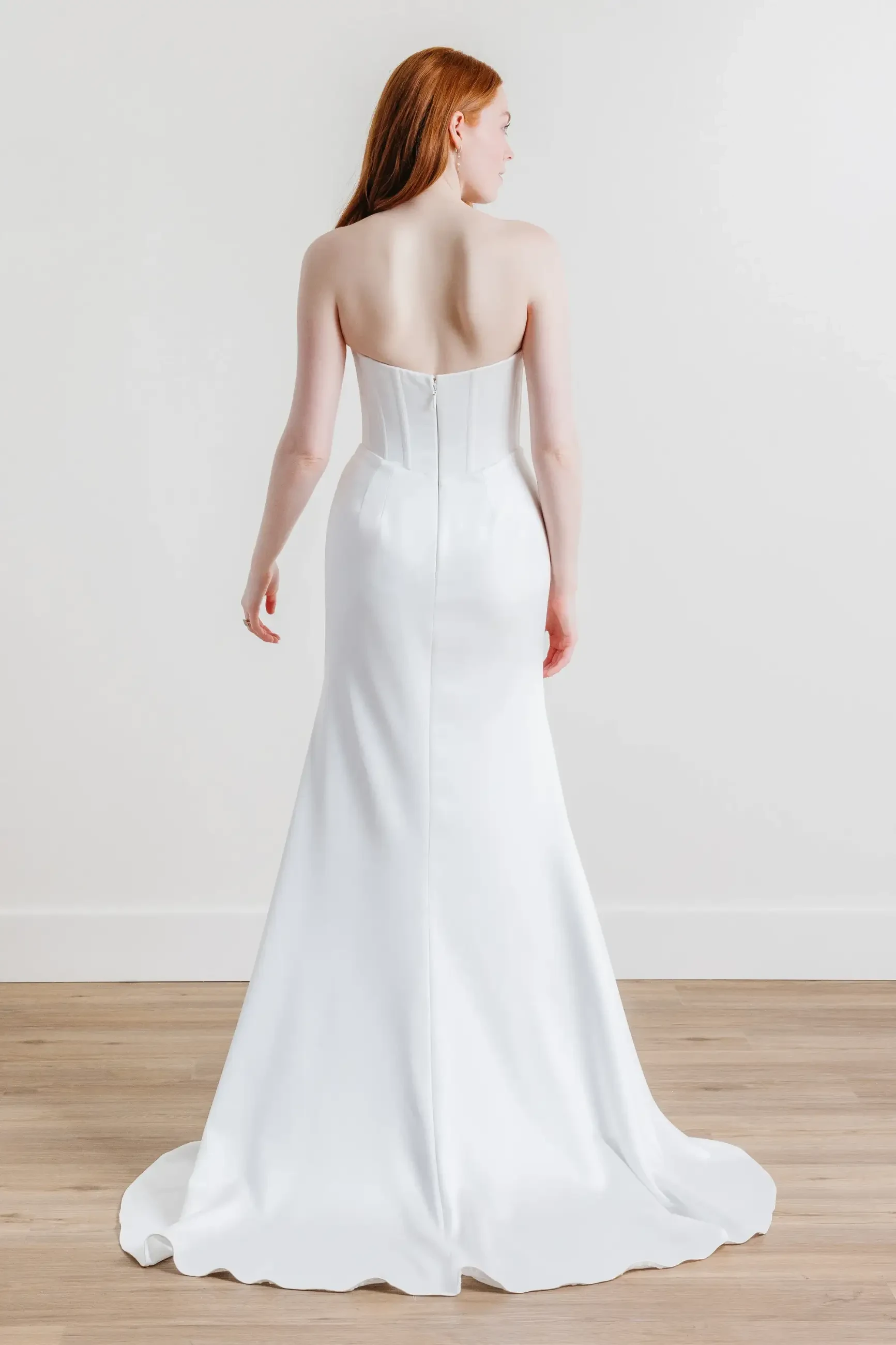 model is wearing a strapless fit and flare bridal gown