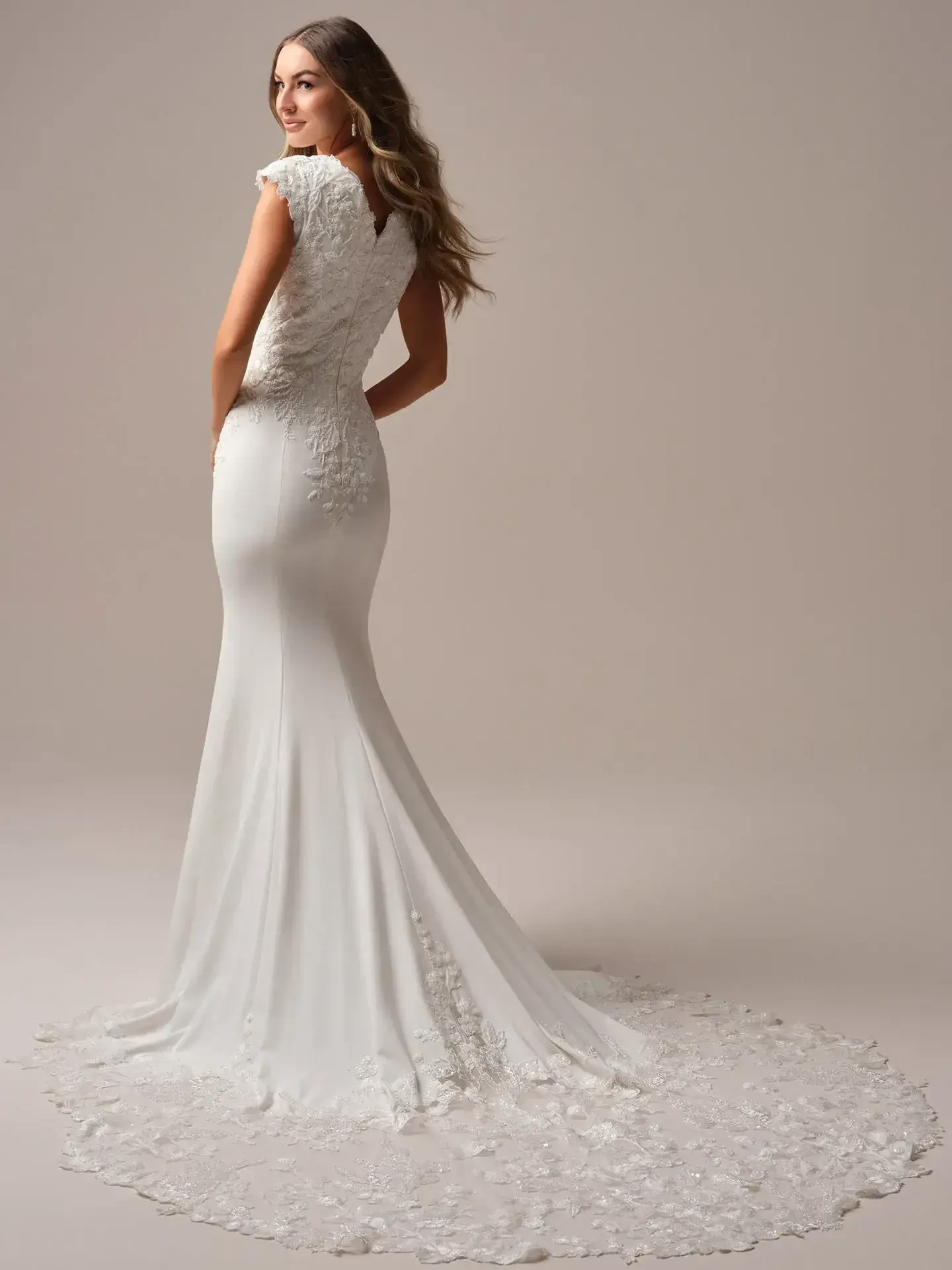 model is wearing a sheath bridal gown with nature inspired details