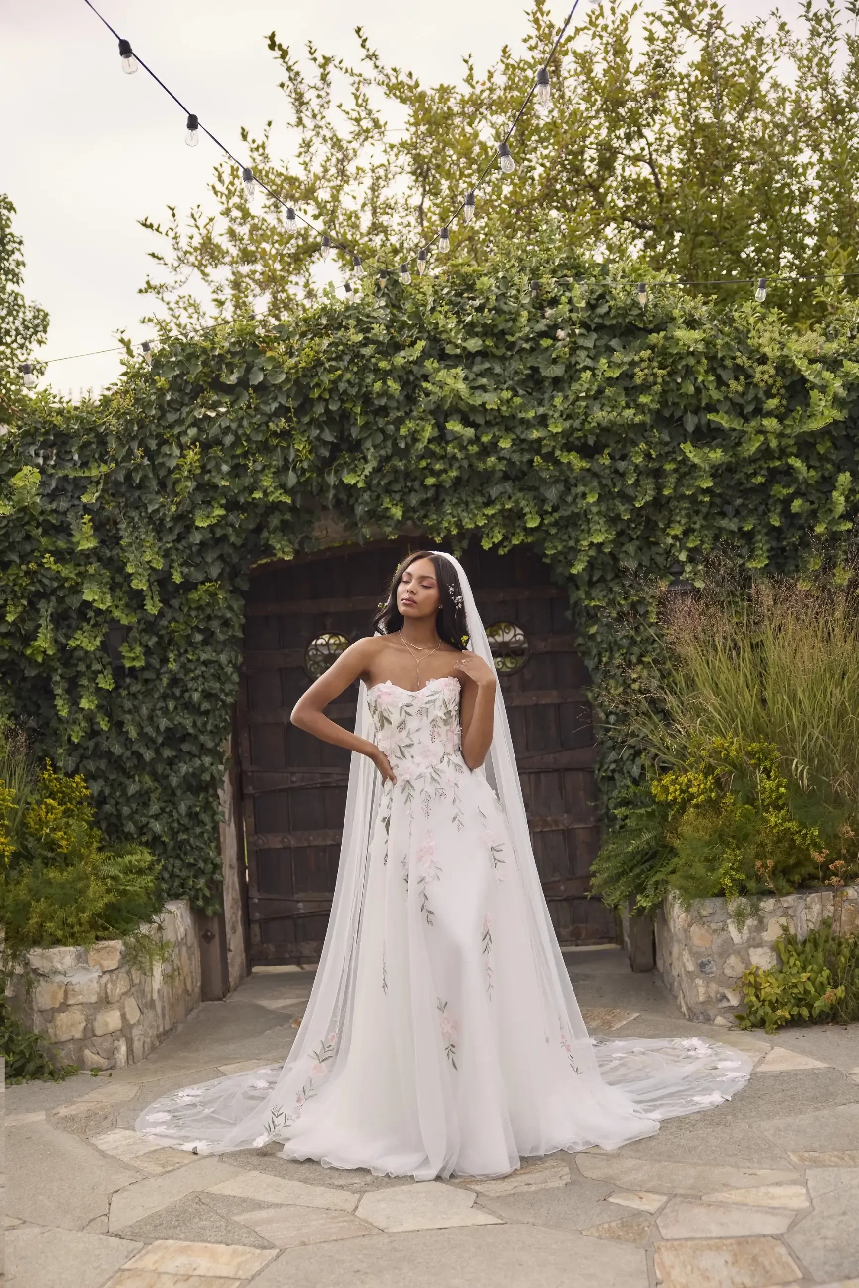 model is wearing an ivory wedding dress with multicolored florals