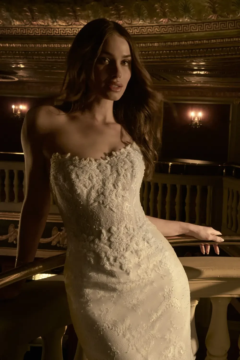 model is wearing a strapless lace fit and flare bridal gown