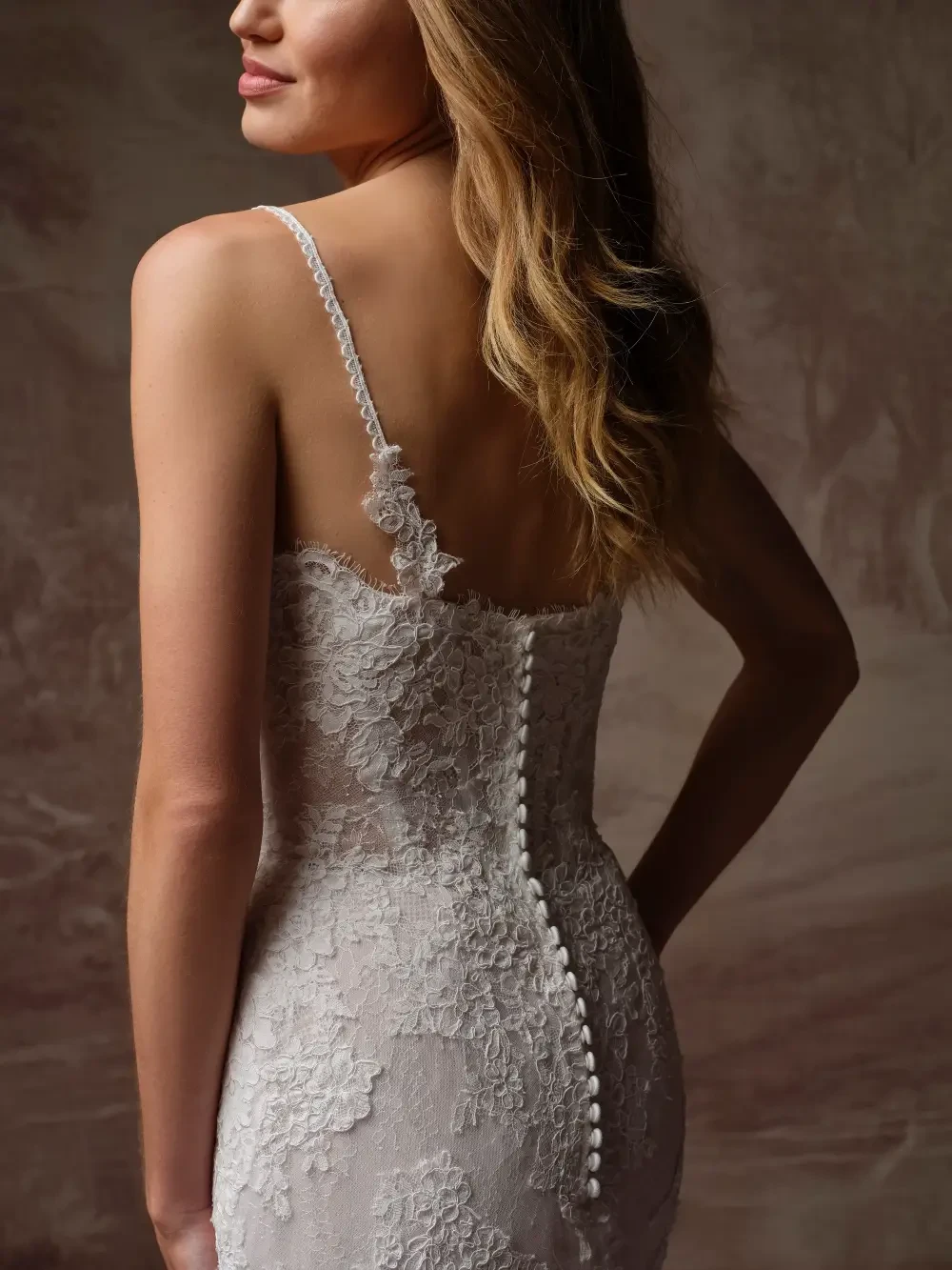 model is wearing an open back bridal gown