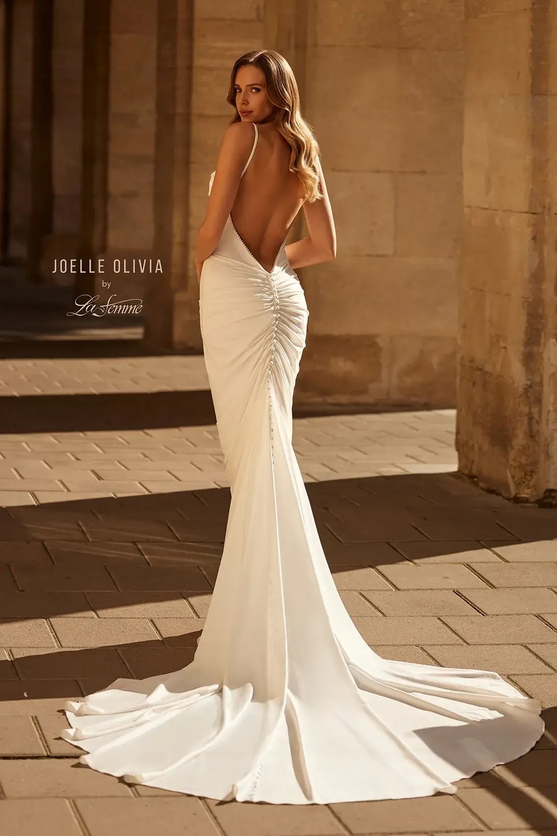 model is wearing a sleeveless minimalist wedding dress with delicate spaghetti straps