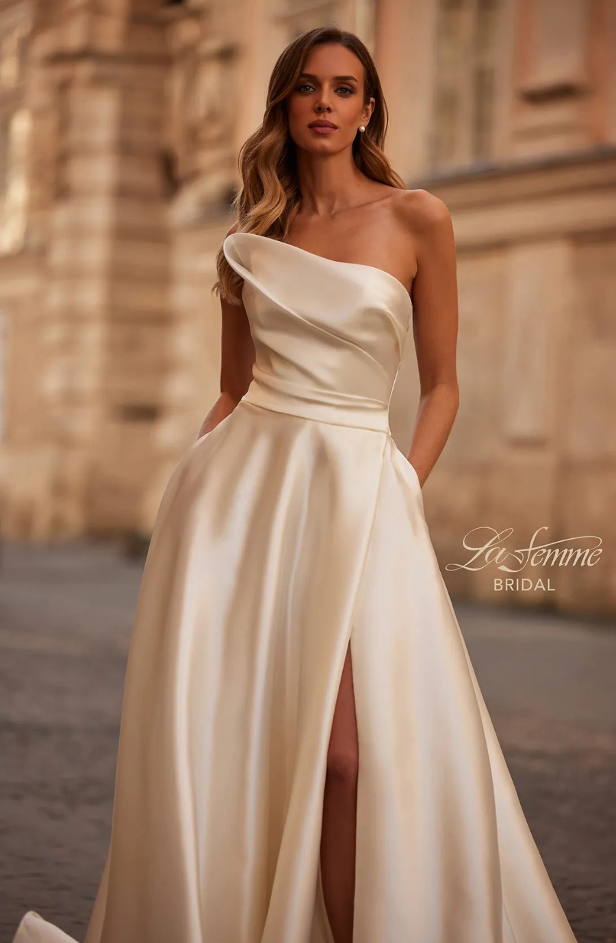 Model is wearing the La Femme Maggie gown, a sleek satin ballgown with a high slit, one-shoulder asymmetrical neckline, and structured silhouette.