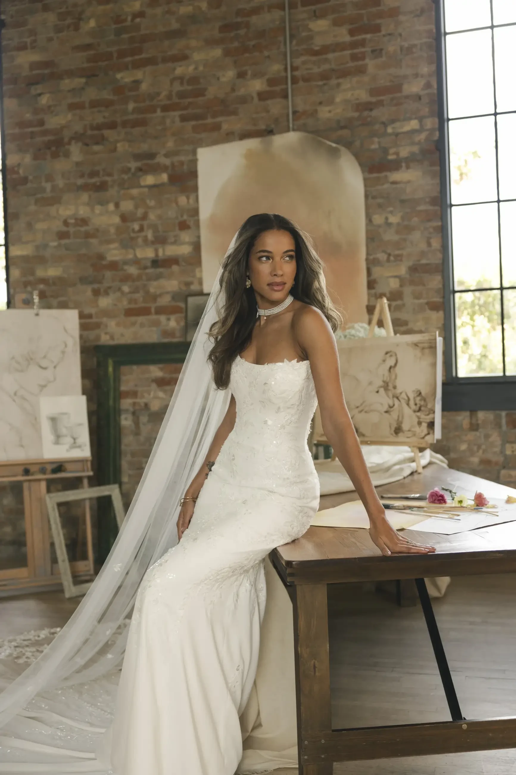 model is wearing a strapless ivory wedding dress